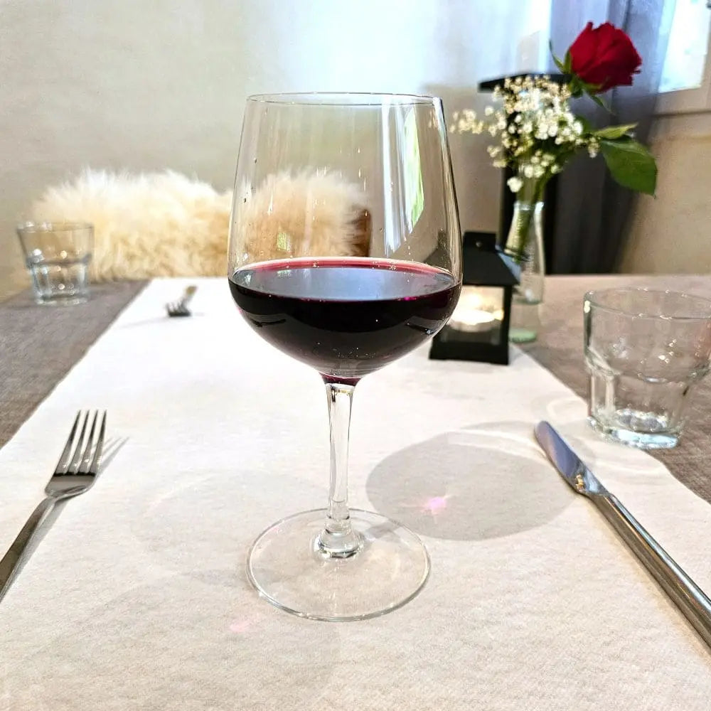 Ein Glas Wein auf einem schön gedeckten Tisch
