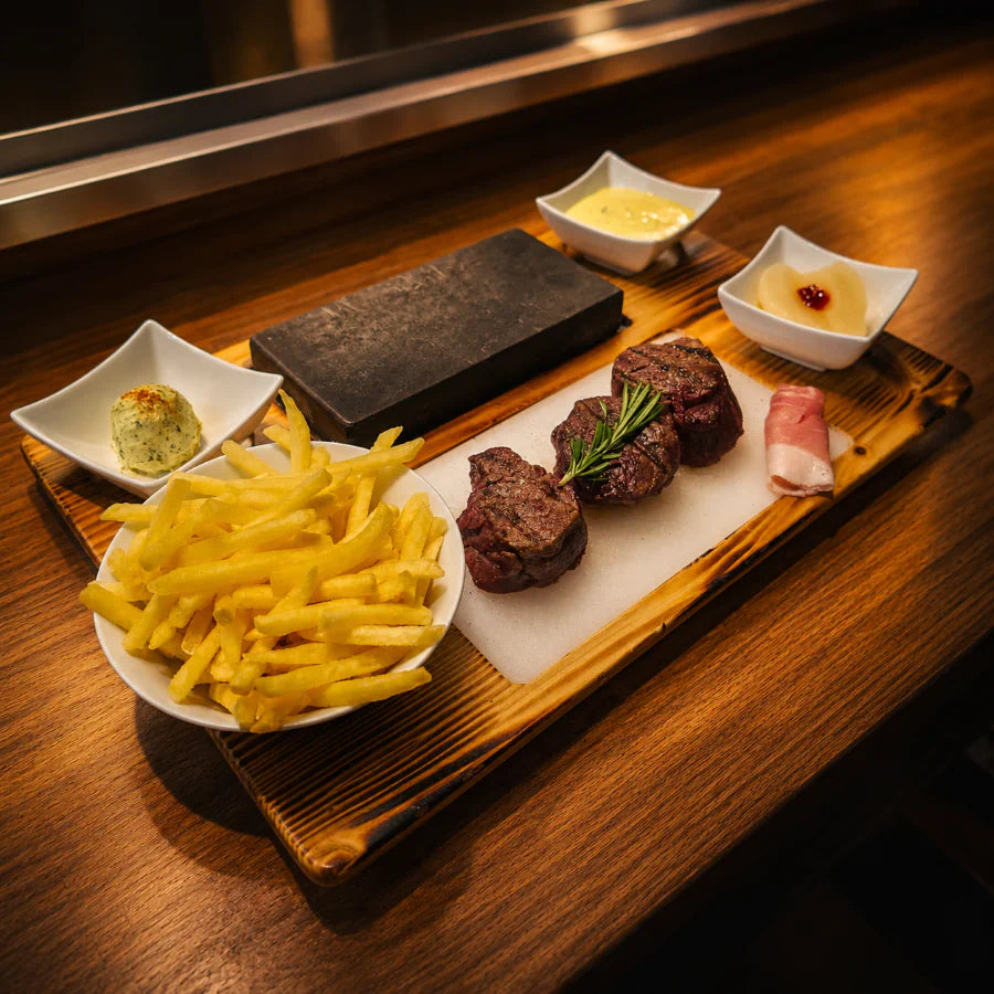Serviertes Fleisch auf dem heißen Stein mit Beilagen im Restaurant Hazienda in Niederhünigen.