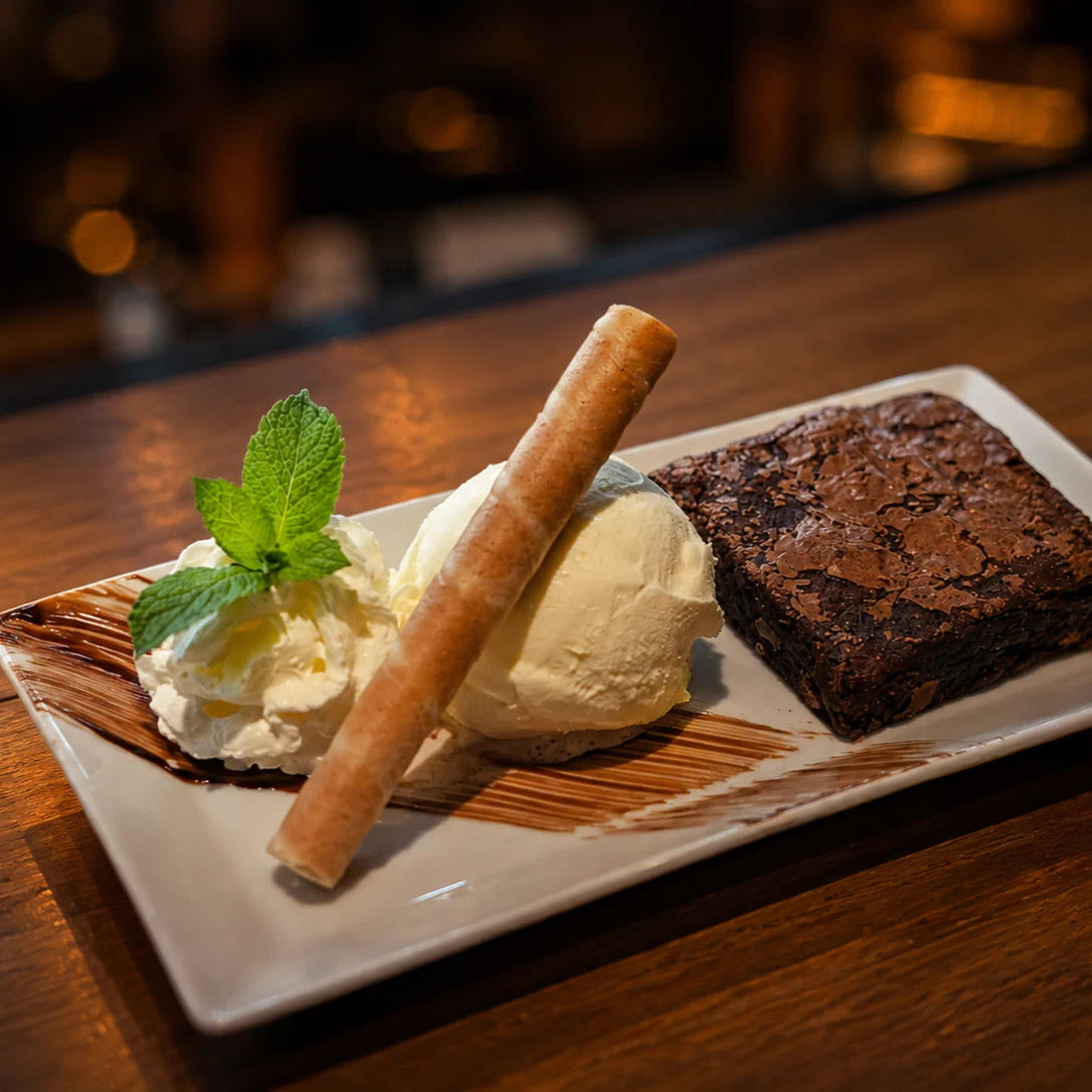 Warmer Schokoladen-Brownie mit Glace nach Wahl und Rahm im Restaurant Hazienda in Niederhünigen.